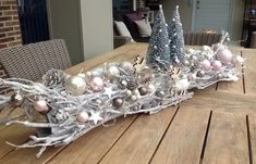 a wooden table topped with lots of ornaments and christmas tree decorations on top of it