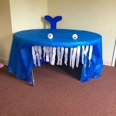 a blue table covered in paper with eyes on it