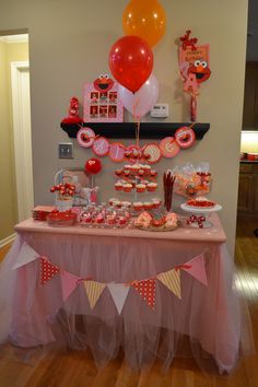 a table topped with lots of desserts and balloons