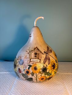 a painted pear shaped vase sitting on top of a table