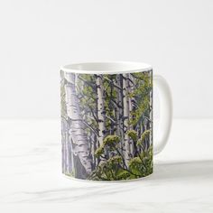 a coffee mug with trees and leaves on it