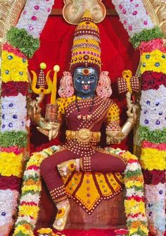 an idol is sitting in the middle of a stage with flowers and decorations around it