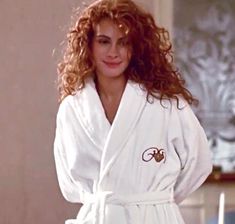 a woman with curly hair wearing a robe