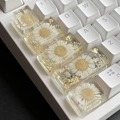 the keyboard is decorated with daisies and gold flakes