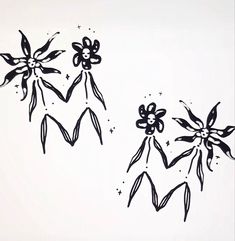 three black and white flowers are drawn on a sheet of paper with stars in the background