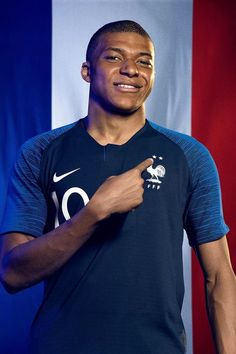 a young man is posing for a photo in front of an american flag wearing a nike shirt