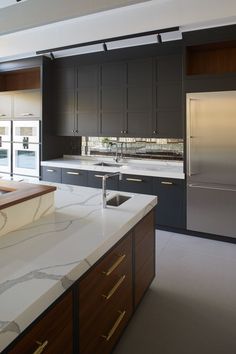 a large kitchen with marble counter tops and stainless steel refrigerator freezer, oven and dishwasher