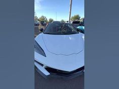 a white sports car parked in a parking lot