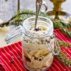 a jar filled with ice cream sitting on top of a red towel next to a christmas tree