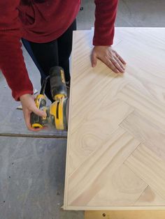 a person using a power tool to cut plywood