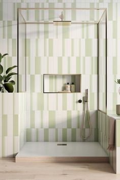 a bathroom with green and white tiles on the walls, shower head, toilet seat and shelf