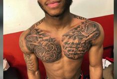 a man with tattoos on his chest posing for the camera