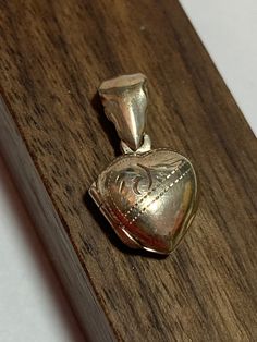 "This is a beautiful, vintage, genuine sterling silver heart locket with a pretty etched design on the front. The dainty locket measures about 7/8\" by 1/2\" (About 1/2\" in length without its bale). The bale opening is 3/8\". The details on the locket are so pretty.  The locket has room for two photos or other memorabilia inside (inside area is about 1/4\" in length).   The locket weighs about 2 grams and is stamped 925. Very pretty. Would also look beautiful on a charm bracelet. See pictures for details.  More gorgeous jewelry here, and some on BIG clearance in my shop:  www.etsy.com/shop/BargainBitz" Vintage Silver Jewelry For Valentine's Day, Victorian Heart Pendant Locket Necklace For Anniversary, Antique Heart Charm Locket Necklace For Anniversary, Antique Hallmark Jewelry For Valentine's Day, Silver Heart Locket Necklace Collectible, Antique Heart Pendant Locket Necklace For Anniversary, Victorian Silver Jewelry For Valentine's Day, Antique Silver Engraved Locket Necklace For Anniversary, Antique Silver Engraved Jewelry For Valentine's Day