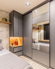 a bedroom with grey walls and built in shelving units on either side of the bed