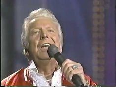 an older man singing into a microphone