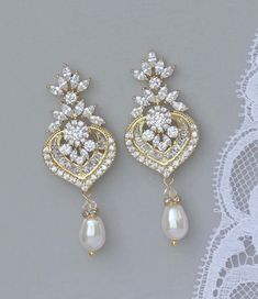 "'Camille' gold chandelier earrings have been designed with sparkling cubic zirconium 'diamonds' and completed with a Swarovski pearl drop in your color choice. They are a beautiful and flattering earring, while being comfortable to wear for many hours. Princess perfect! We used ivory white pearls in this listing. Measurements: Length - 2 1/4\" (5.5 cm ) Width - 7/8\" ( 2.2 cm) 💟 Items that coordinate or are frequently bought together (as in the photos/collages): https://www.etsy.com/listing/49 Chandelier Earrings Gold, Earrings Pearl Drop, Bridal Earrings Chandelier, Gold Chandelier Earrings, Earrings Chandelier, Special Occasion Jewelry, Bridal Accessories Jewelry, Bridal Earrings Drop, Gold Bridal Earrings