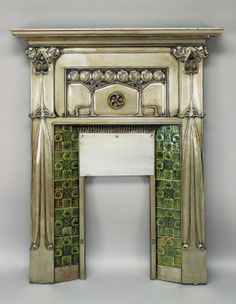 an ornate fireplace surround with green tiles