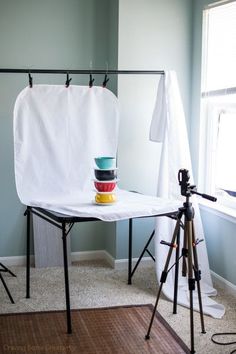 a photo studio setup up with a camera and tripod in front of the window