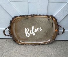 a metal tray with the word before painted on it sitting in front of a door