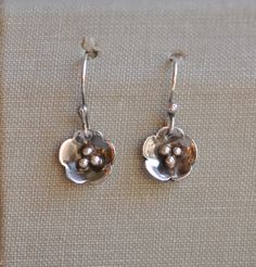 Pretty and dainty, sterling silver flower earrings. These are hand forged by me in my workshop at home. The silver has been polished then dipped in liver of sulfer to oxidise it, then polished again to bring the silver shine through the dark patina. The drop overall is approx 28mm, and the flowers are approx 11mm diameter. All my jewellery is simple and understated, no bling, nothing flashy, and not mass produced. Every piece is hand forged with love for the craft of silversmithing, using tradit Minimalist Sterling Silver Flower Charm Earrings, Minimalist Sterling Silver Flower Earrings, Dainty Sterling Silver Dangle Flower Earrings, Delicate Silver Nickel-free Flower Earrings, Silver Delicate Nickel-free Flower Earrings, Delicate Silver Flower Earrings Nickel-free, Dainty Nickel-free Flower Earrings For Anniversary, Delicate Silver Flower Earrings Nickel Free, Delicate Sterling Silver Flower Earrings For Jewelry Making