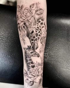 a giraffe and a baby giraffe with flowers on it's leg