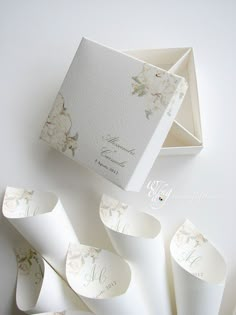 an open box with some paper in it on top of a white surface and the inside is decorated with flowers