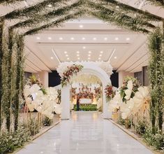 the entrance to a wedding venue decorated with flowers and greenery on either side of the aisle