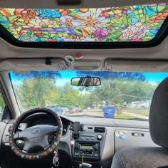 the interior of a car with a colorful stained glass ceiling in the passenger side window