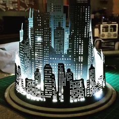 a paper cut out of a city with buildings on it's sides and lights in the middle