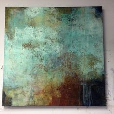 an abstract painting is hanging on the wall in front of a white wall with a blue and brown background