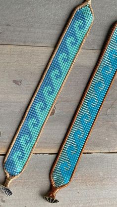 two pieces of blue beaded fabric on wooden floor with tassels and beads