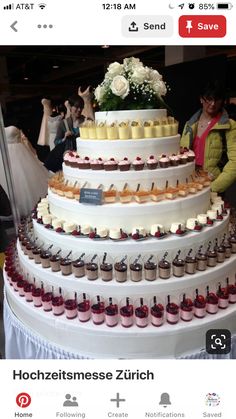 a wedding cake with cupcakes and flowers on the top tier is surrounded by people