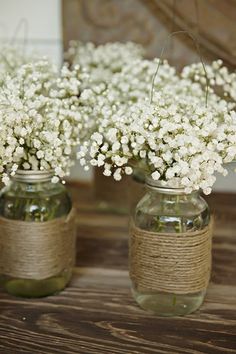 three mason jars filled with baby's breath flowers