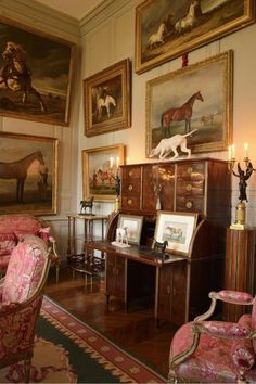 a living room filled with furniture and paintings on the wall