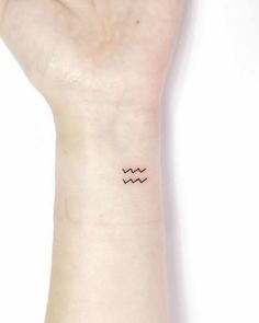 a person's wrist with a small wave tattoo on the left side of their arm