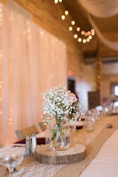 the table is set with flowers in vases and place settings for guests to sit at