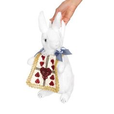 a white stuffed rabbit with a red heart on it's chest is being held by a hand