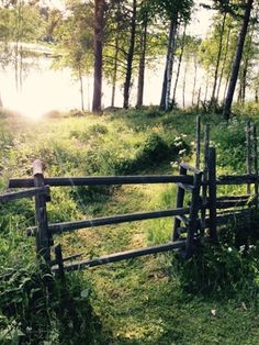 a wooden fence in the middle of a grassy field