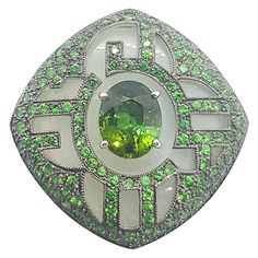 Jade 37.40 carats, Green Tourmaline 3.97 carats with Tsavorite 5.46 carats Ring set in 18 Karat White Gold Settings Width: 3.6 cm Length: 3.6 cm Ring Size: 53 Total Weight: 37.52 grams "We first opened doors in 1980 when it was then situated in the vicinity of the Victory Monument; a small and modest storefront with a couple of counters. From its humble beginnings to where it stands today, our company has proven its abilities as a jeweler. Since the beginning, we have been supplying fine quality