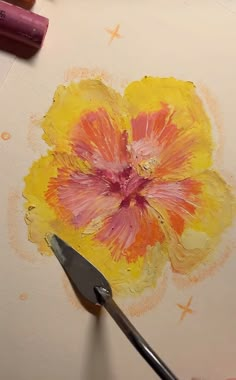 someone is painting a flower with watercolors on paper and crayon pens