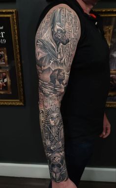 a man's arm with tattoos on it and an image of the egyptian god