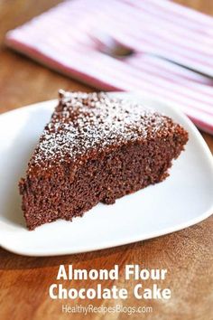 a piece of chocolate cake on a plate with powdered sugar over it and the words, almond flour chocolate cake