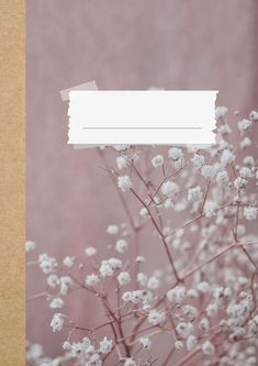 there is a small plant with white flowers in the foreground and an empty piece of paper above it