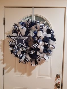 a wreath on the front door decorated with black, white and blue ribboned stars