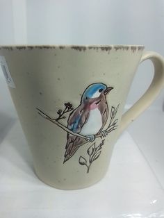 a coffee cup with a bird painted on it