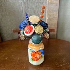 a vase filled with lots of different colored glass items on top of a wooden table