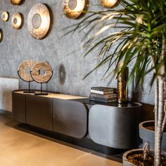 a living room filled with lots of furniture next to a wall covered in gold circles