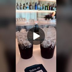 two starbucks cups are sitting on a table