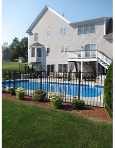 a house with a swimming pool in front of it and a deck on the other side