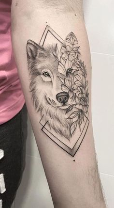 a woman's arm with a tattoo of a wolf and flowers on the side